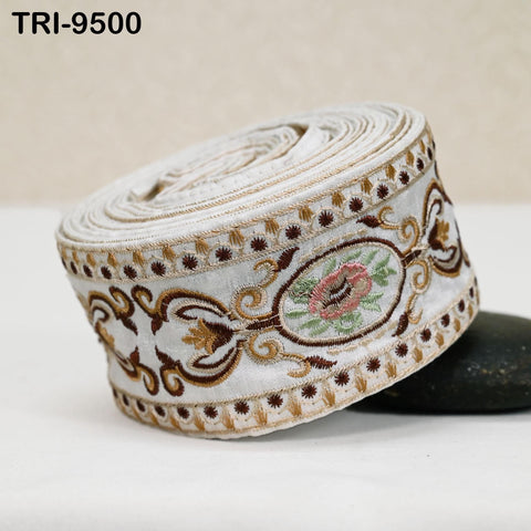 A decorative fabric with intricate embroidery, including floral and leaf patterns, is shown in the image.