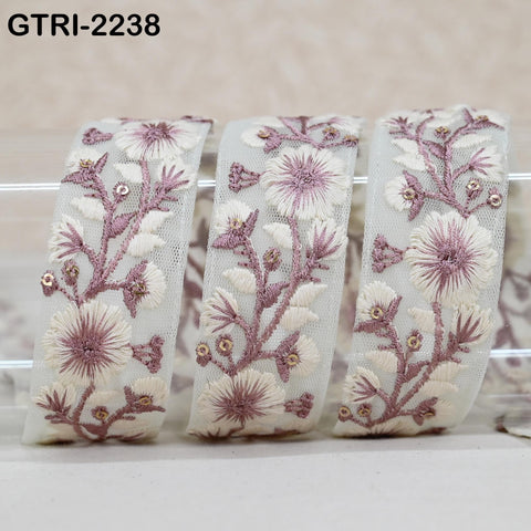 three white fabric pieces with intricate floral embroidery in shades of pink and white.