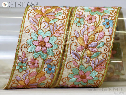 a decorative floral embroidered ribbon with a floral pattern in various colors, including pink, green, and blue. The ribbon appears to be made of fabric and is displayed against a plain background.