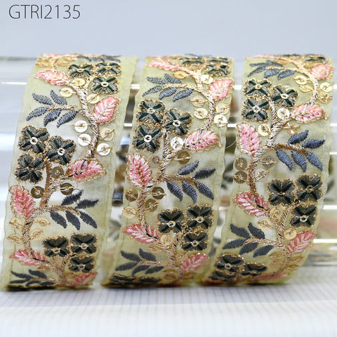 a close-up view of a decorative fabric with a floral pattern, featuring a combination of pink, green, and black colors.
