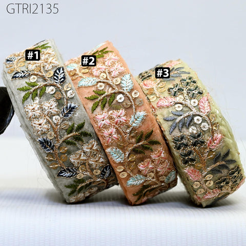 three decorative fabric pieces with intricate floral embroidery, each with a unique color and pattern.