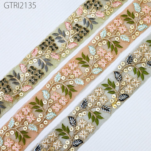 three decorative fabric pieces with intricate floral embroidery and sequin embellishments. The pieces are arranged in a row, showcasing the detailed craftsmanship and vibrant colors of the designs.