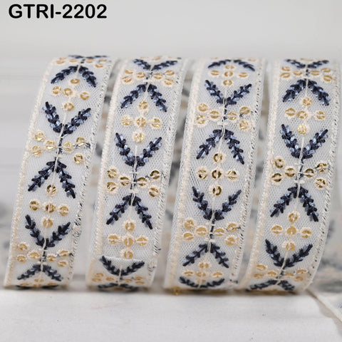 A close-up image of a decorative ribbon with a repeating floral pattern in shades of blue and gold.