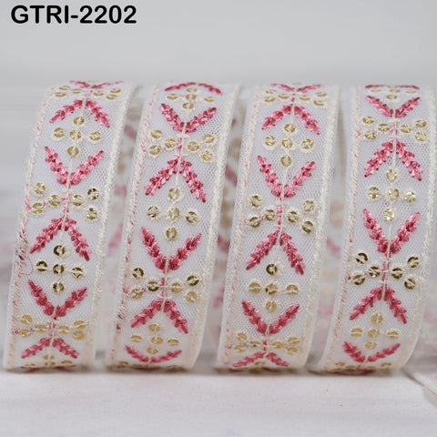 A close-up image of a decorative ribbon with a floral pattern in pink and gold colors.