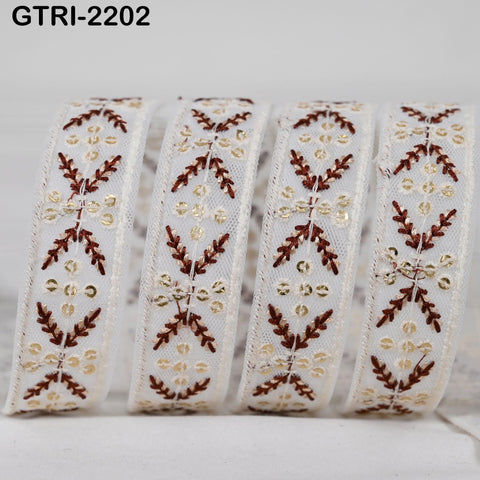 A close-up image of a decorative ribbon with a repeating pattern of white and brown floral designs.