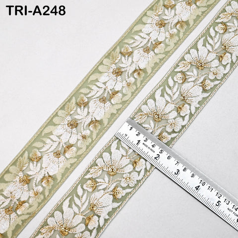 a decorative fabric with a floral pattern, featuring a ruler placed on top of it to measure its length.