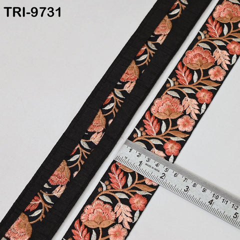 a close-up view of a decorative fabric with a floral pattern in shades of black and orange. A ruler is placed on the fabric, indicating its size.