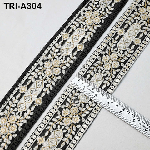 a close-up view of a decorative black and white fabric with a floral pattern. A ruler is placed on the fabric, indicating its size.