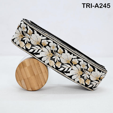 A decorative black and white fabric with a floral pattern, featuring a wooden object in the foreground.