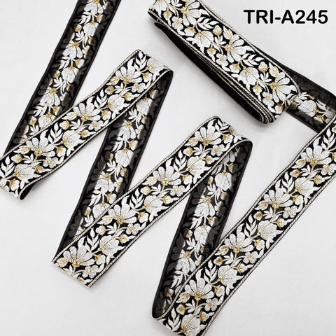 several spools of black and white floral embroidery ribbon, with the spools arranged in a zigzag pattern.