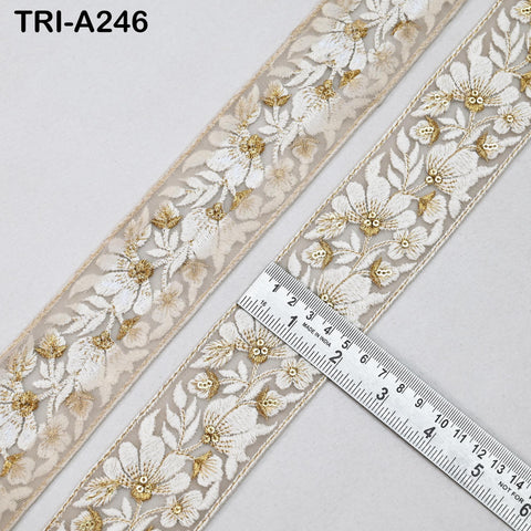 a decorative fabric with a floral pattern, featuring a ruler placed on top of it to measure its length.