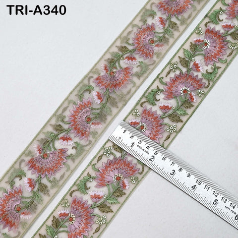 two pieces of fabric with a floral pattern, and a ruler is placed on top of them to measure their length.