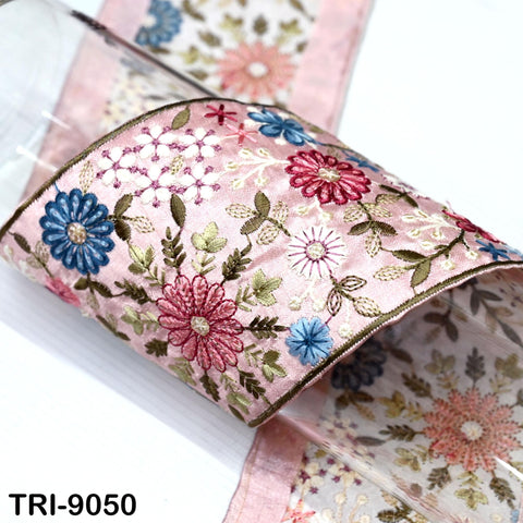 a close-up view of a decorative fabric with a floral pattern, including pink, blue, and white flowers and leaves.