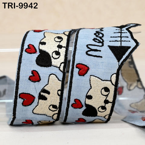 A blue ribbon with a playful cat design and red hearts printed on it.
