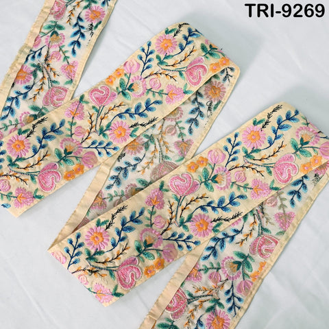 a close-up view of a decorative fabric with a floral pattern. The fabric appears to be a beige color and features a variety of colorful flowers and leaves, creating a visually appealing and intricate design.