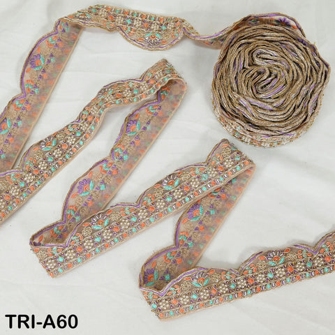 a collection of decorative fabric pieces, including a spool of thread with a floral pattern and several pieces of fabric with intricate embroidery.