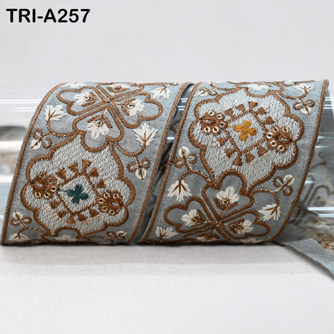a decorative fabric with intricate floral patterns in shades of gray and brown, featuring a repeating design of flowers and leaves.