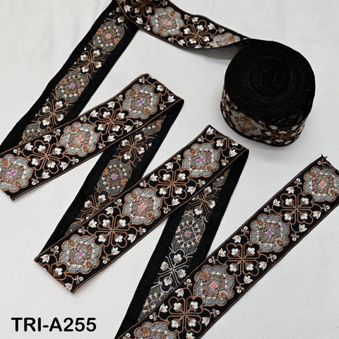 several spools of black and gold embroidered fabric, arranged on a white background.