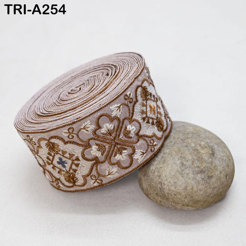 a decorative fabric with a floral pattern, placed on a white surface next to a small, round, gray stone.
