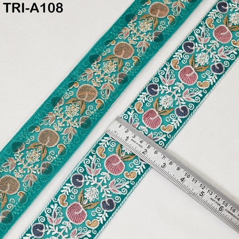 two pieces of fabric with intricate floral embroidery in shades of green and blue. A ruler is placed on top of the fabric, indicating the size of the fabric.