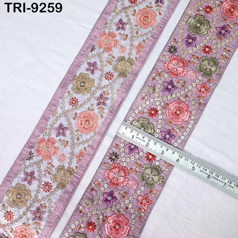 two pieces of fabric with a floral pattern, one with a purple border and the other with a pink border. A ruler is placed between the two pieces of fabric, indicating their size.
