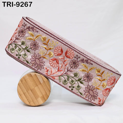 a decorative fabric with a floral pattern, including pink, green, and yellow flowers, and a wooden object with a textured surface.