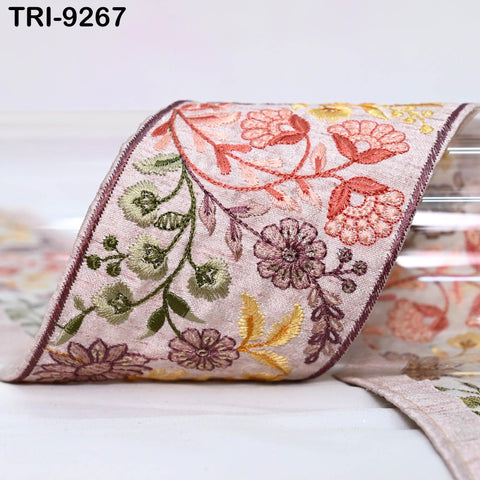 a decorative floral embroidered ribbon with a pink and green floral pattern.