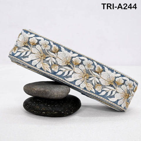 A decorative fabric with a floral pattern is placed on top of two rocks, with a textured surface.