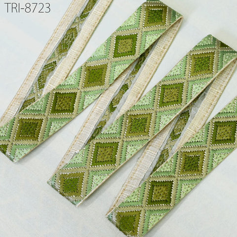 a collection of green and beige patterned fabric strips arranged on a white background.