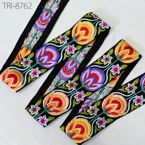 a collection of colorful, embroidered fabric pieces with floral patterns. The fabric pieces are arranged in a row, with each piece featuring a variety of vibrant colors and intricate designs.