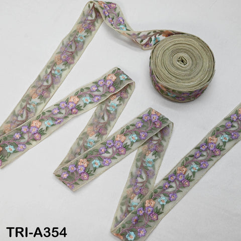 a collection of decorative fabric pieces, including a spool of thread with a floral pattern and several pieces of fabric with a similar floral design.