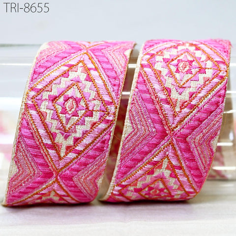 two pieces of pink and white embroidered fabric with a geometric pattern, placed side by side.