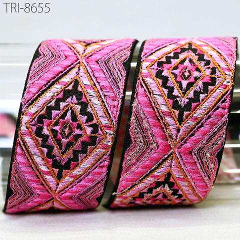two decorative fabric pieces with a pink and black geometric pattern.