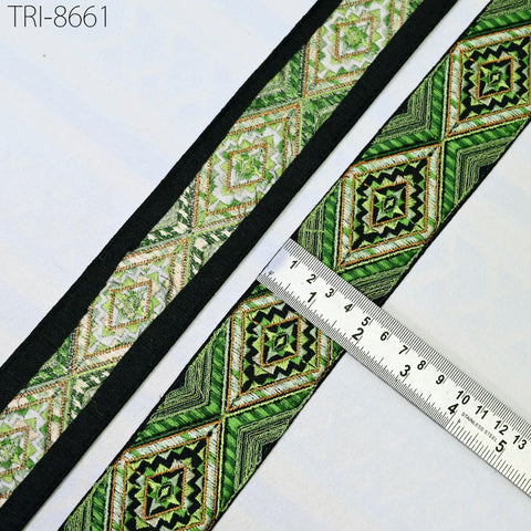 a close-up view of a decorative green and black fabric with a repeating diamond pattern. A ruler is placed next to the fabric, indicating its size.