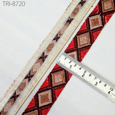 a close-up view of a decorative ribbon with a diamond pattern in red, brown, and beige colors. A ruler is placed next to the ribbon, indicating its size.
