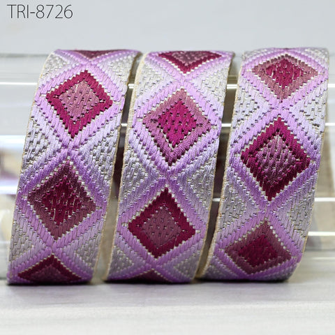 three decorative fabric pieces with a diamond pattern in shades of pink and purple.