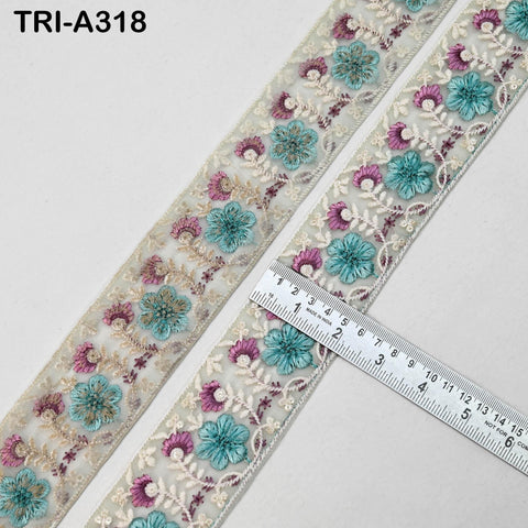 two pieces of fabric with a floral pattern, including blue and pink flowers, arranged on a white background. A ruler is placed next to the fabric, indicating the size of the fabric pieces.