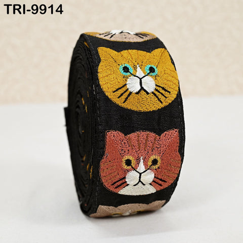 A black and yellow cat-themed ribbon with two cat faces on it, one black and one yellow, against a white background.