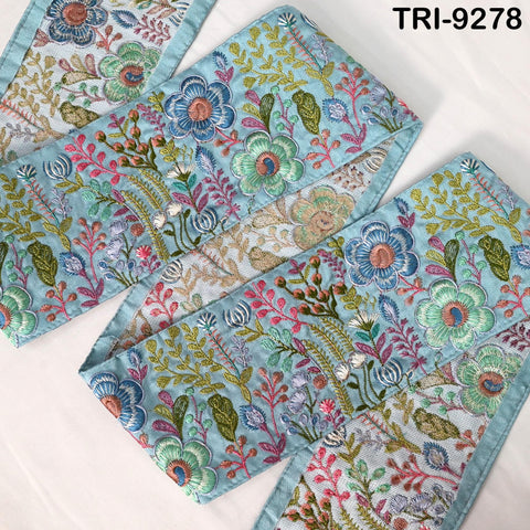 a close-up view of a decorative fabric with a floral pattern in shades of blue, green, and pink. The fabric appears to be a textile or textile-like material, with intricate embroidered designs and patterns. The image does not contain any text or other discernible objects or actions.