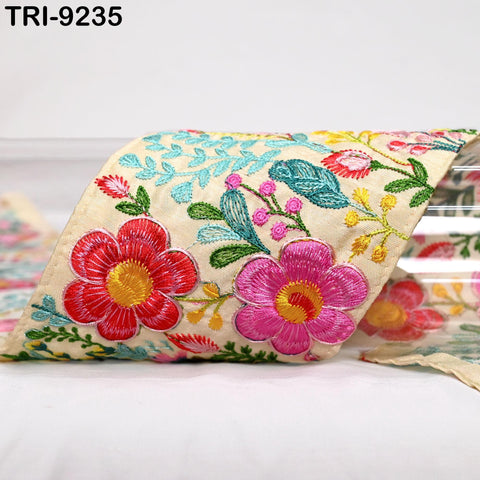 a close-up view of a decorative fabric with a floral pattern, including red, pink, and yellow flowers.