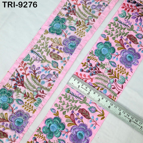 a close-up view of a decorative fabric with a floral pattern in shades of pink and green. A ruler is placed on the fabric, indicating its size.