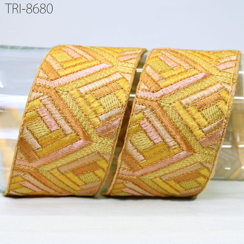 two pieces of fabric with a geometric pattern in shades of yellow and orange, arranged side by side.