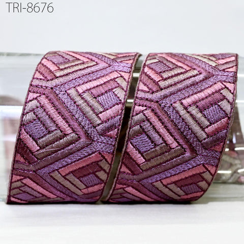 a decorative ribbon with a geometric pattern in shades of pink and purple.