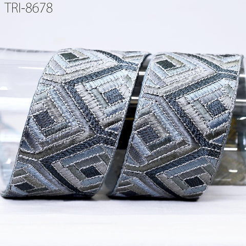 a pair of decorative silver and gray fabric pieces with an intricate geometric pattern.