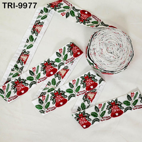 a collection of Christmas-themed ribbons and a spool of ribbon against a white background.