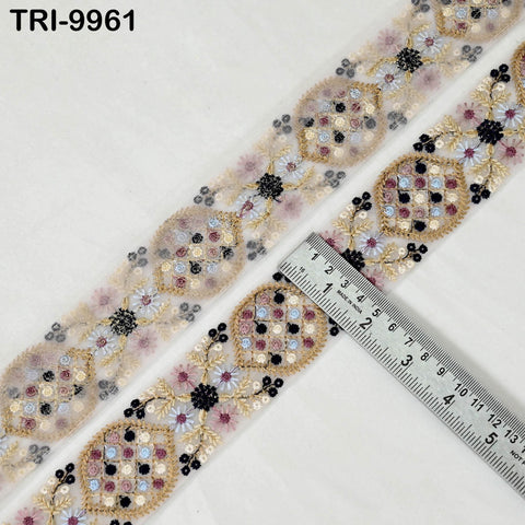 a decorative fabric with a floral pattern, featuring a ruler placed on it to measure its length.