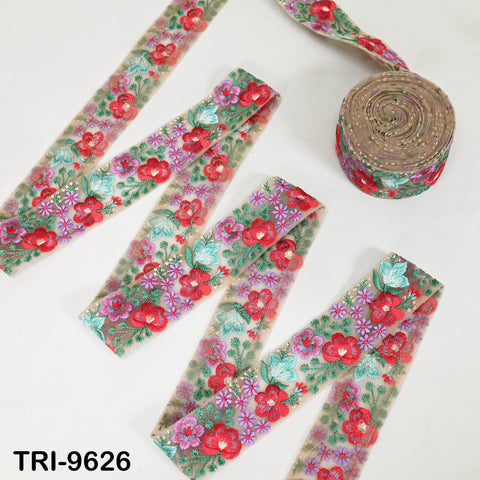 a collection of colorful floral embroidered fabric pieces, including a large piece with a floral pattern and several smaller pieces with different floral designs.