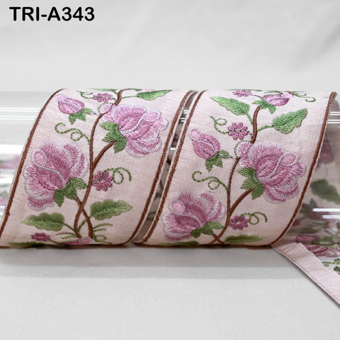 a decorative fabric with a floral pattern, featuring pink flowers and green leaves. The fabric appears to be a ribbon or a piece of cloth with a floral design.