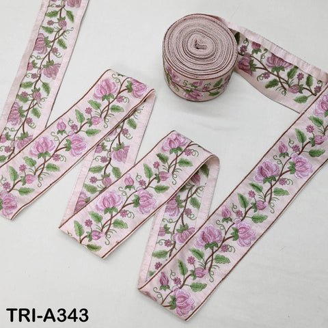 a collection of decorative fabric pieces, including a spool of pink fabric with a floral pattern and several pieces of fabric with a similar floral design.