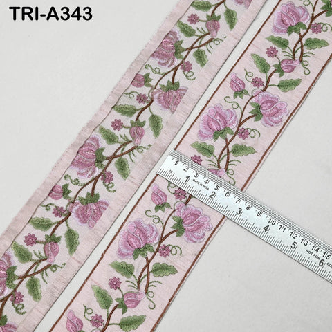 a decorative fabric with a floral pattern, featuring pink flowers and green leaves. A ruler is placed next to the fabric, indicating its size.